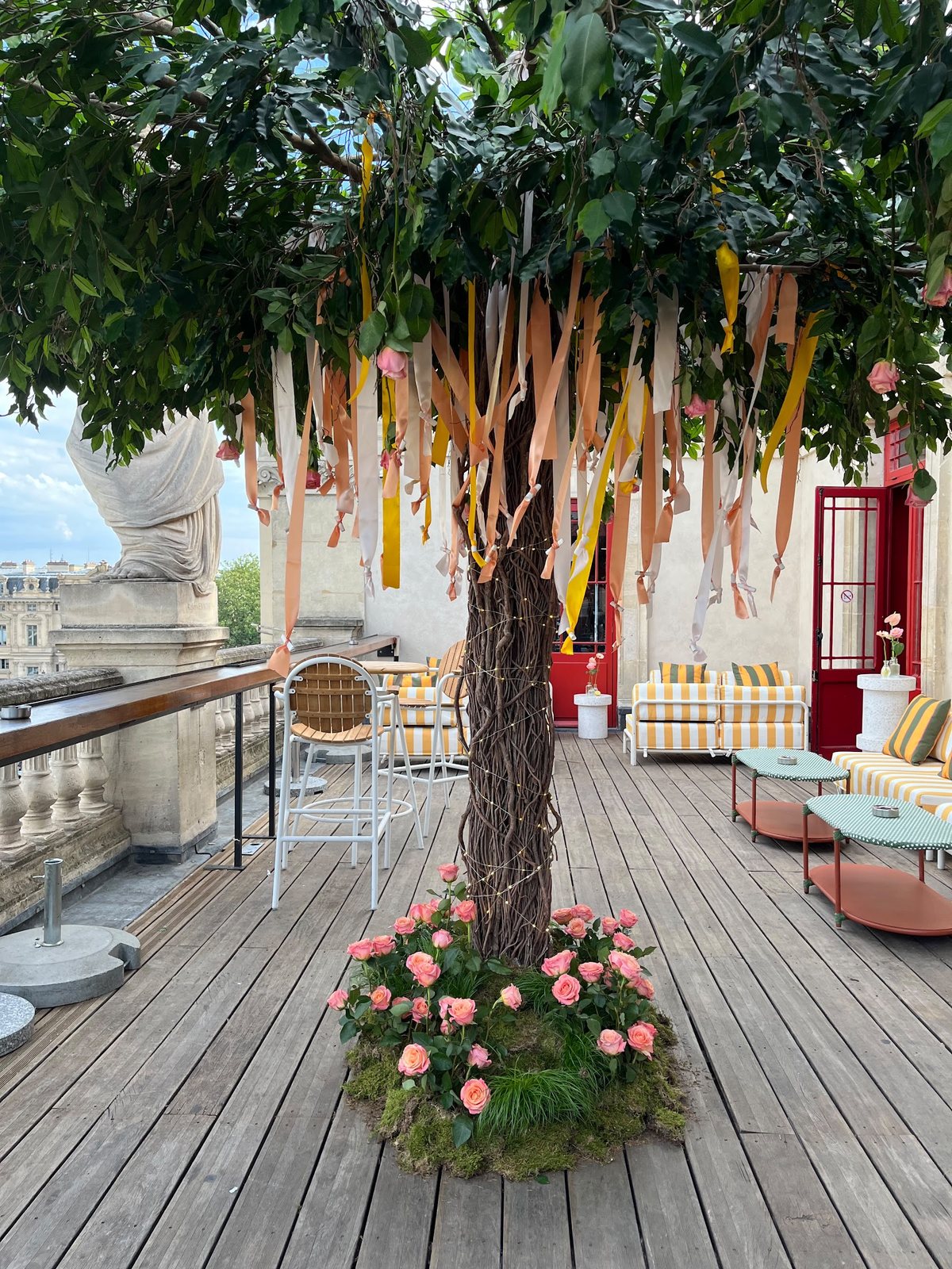 Arbre habillé de rubans et de roses sur une terrasse